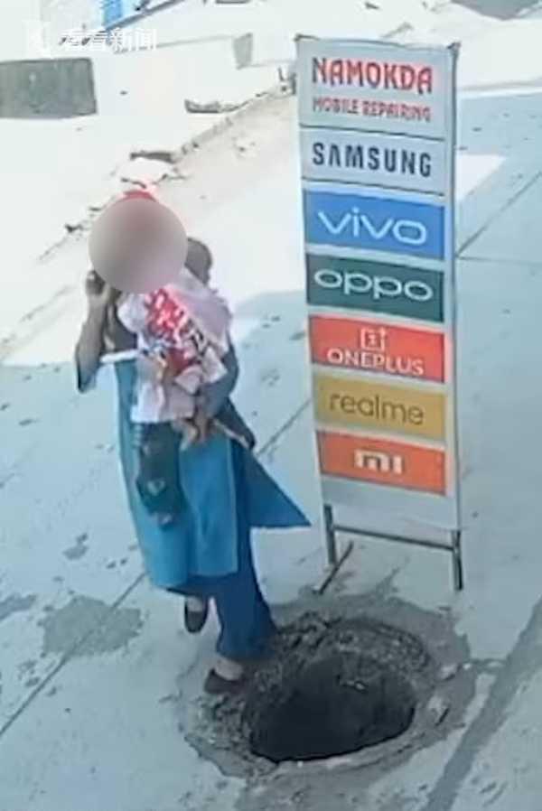 印度母亲抱9个月婴儿玩手机 一脚踩空跌入窨井