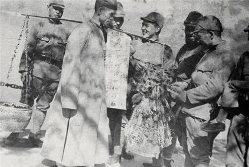 抗战时期真实的老照片：抱着中国儿童的日寇，女子被强迫跪在墙下