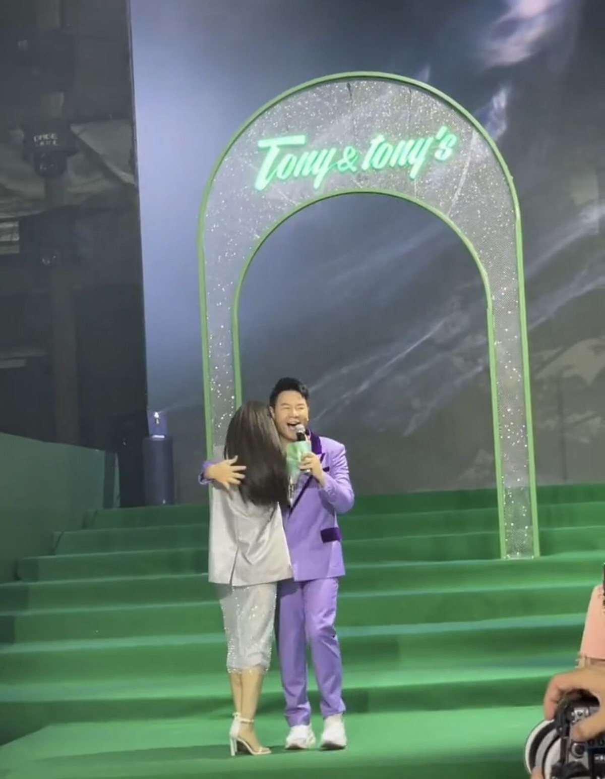 李菲儿牵着男主持人手下楼梯，不慎摔倒在地，被男生搂入怀安慰